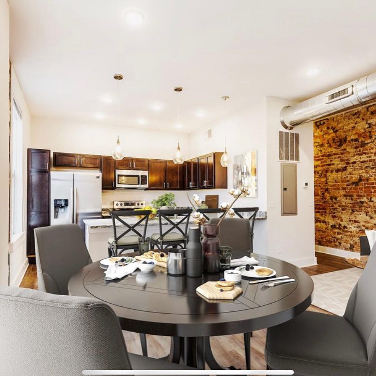 Open kitchen and dining with exposed-brick feature wall